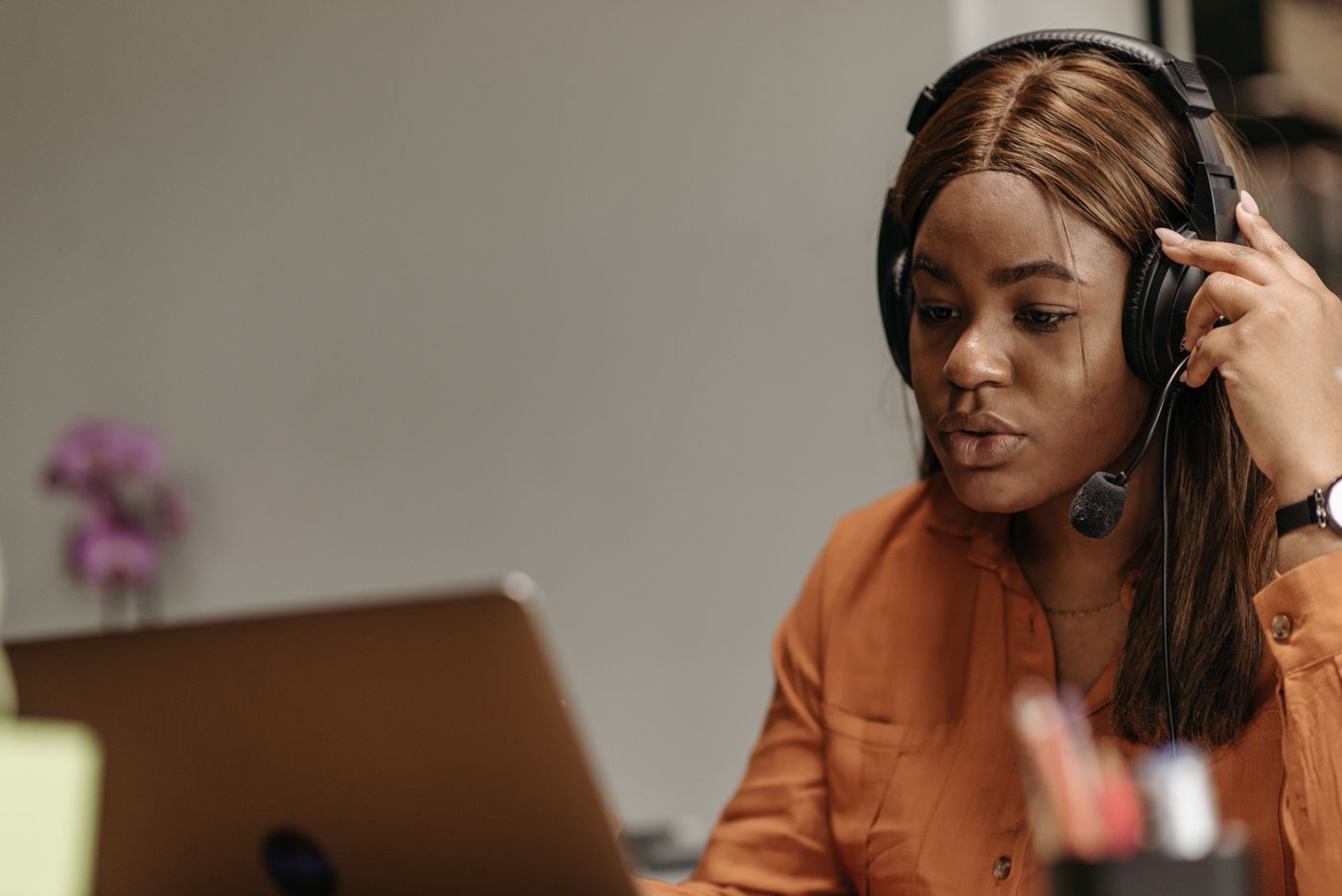 Customer-support professional wearing a headset and working on a laptop