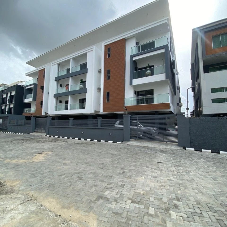 Apartment building with glass balconies and a gated compound